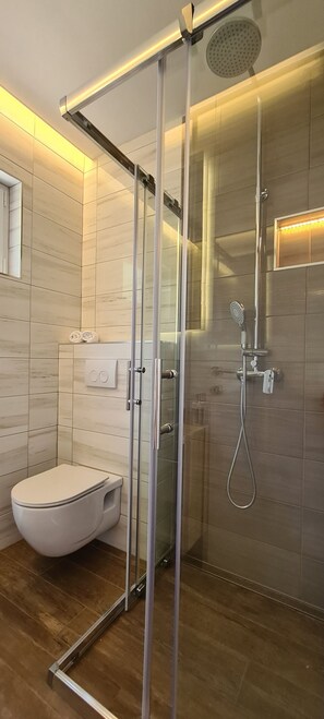A modern bathroom with a glass-enclosed shower, a toilet, and a wooden floor. - Villa Dream Come True (Jelsa)