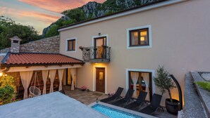 Un bâtiment à deux étages doté d’une piscine, d’un espace extérieur aménagé et d’un balcon.