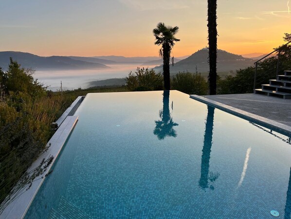 Alberca al aire libre, sombrillas en la alberca y camastros 