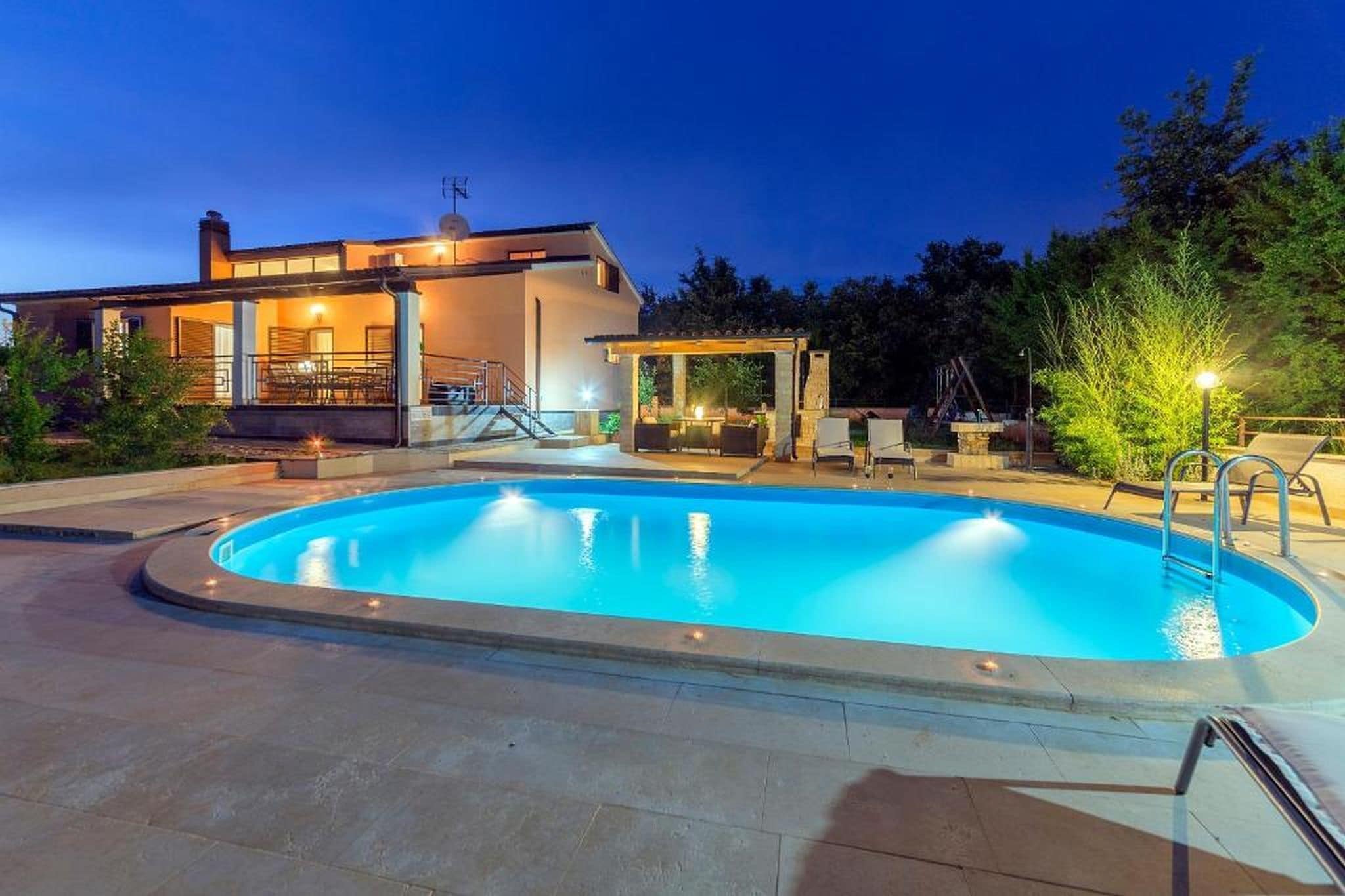 Een buitenzwembad, een verwarmd zwembad en parasols bij het zwembad