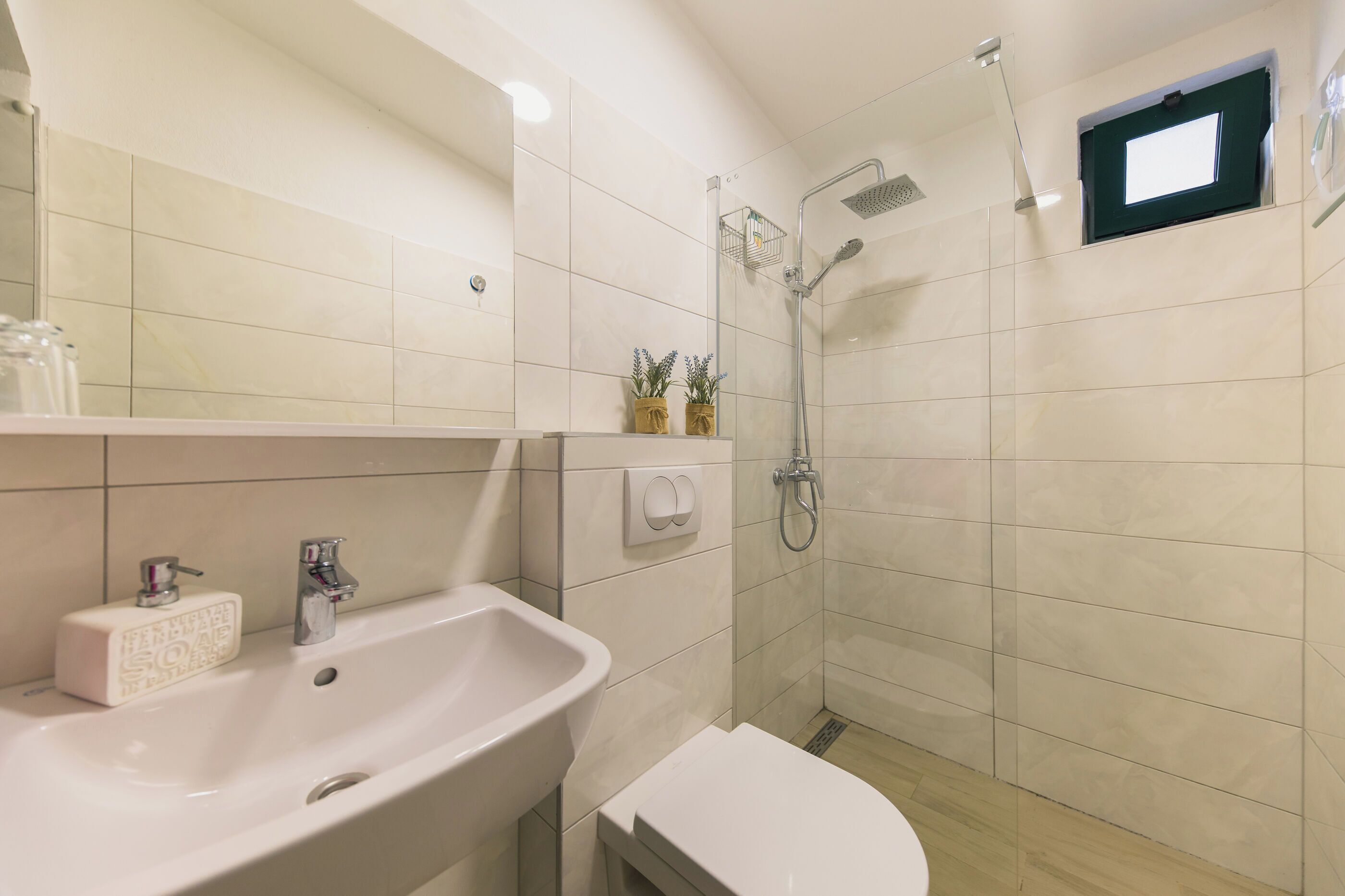 A modern bathroom with a sink, toilet, and shower.
