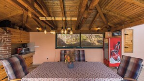 A rustic wooden ceiling, a dining table with a floral tablecloth, and a refrigerator with a Coca-Cola ad. - Villa Magnolia (Zadar)