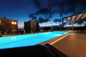 Une piscine offrant une vue sur les bâtiments et un ciel nuageux.