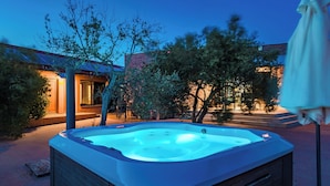 Un bain à remous installé à l’extérieur, avec un bâtiment visible en arrière-plan.
