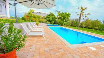 Outdoor pool, a heated pool, open open 24 hours a day, pool umbrellas