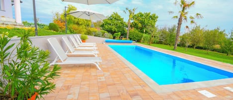 Outdoor pool, a heated pool, open open 24 hours, pool umbrellas
