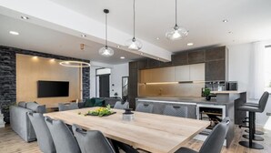 A modern kitchen with a central island, built-in appliances, and a dining area with a large table and chairs. - Villa Eden With Heated Pool (Omis)