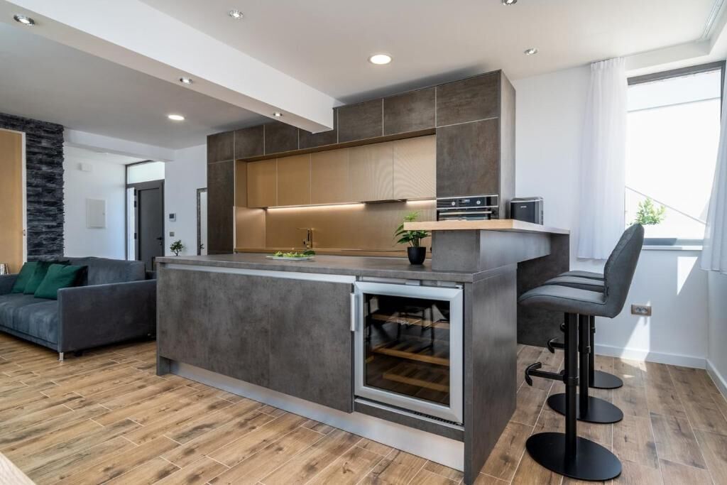 Une cuisine moderne dotée d’un îlot central, d’appareils électroménagers intégrés et d’un tabouret de bar.