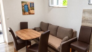 Ein Wohnzimmer mit einem Holztisch, einem braunen Sofa und passenden Stühlen.