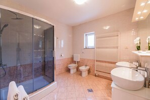 A modern bathroom with a glass-enclosed shower, a toilet, bidet, and a sink. - Villa Roko (Novi Vinodolski)