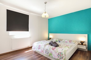 A bedroom with a bed, a nightstand, a lamp, a radiator, and a window with blinds. - Villa Spacious (Zminj)