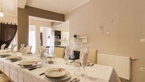 A dining area with a long table set for a meal, a kitchen in the background, and a radiator on the wall. - Villa Spacious (Zminj)