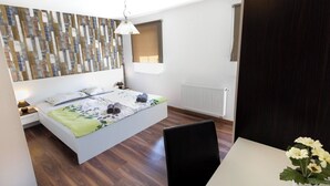 A bedroom with a bed, a bedside table, a lamp, a radiator, a chair, and a small table with flowers. - Villa Spacious (Zminj)