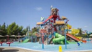 En vattenpark med en stor vattenrutschkana, en vågbassäng och en skylt med texten ”Solaris Aquapark”.