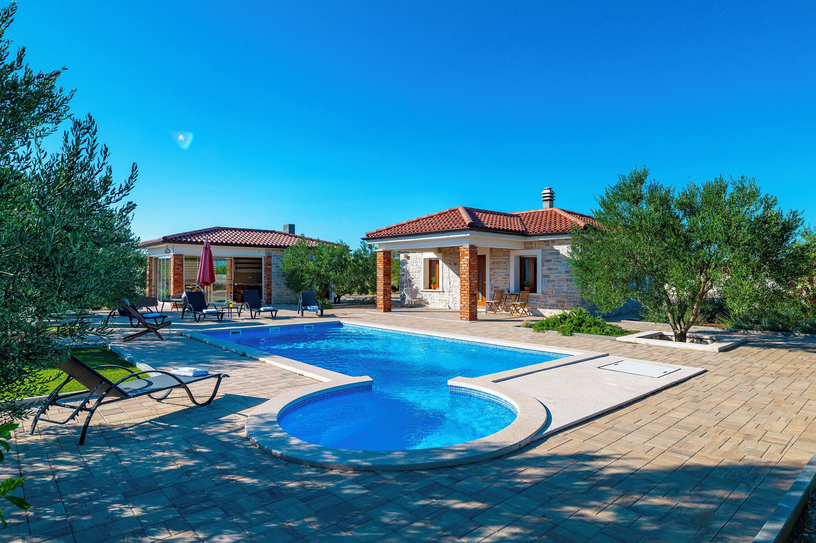 A swimming pool with lounge chairs and a small building with a red-tiled roof.