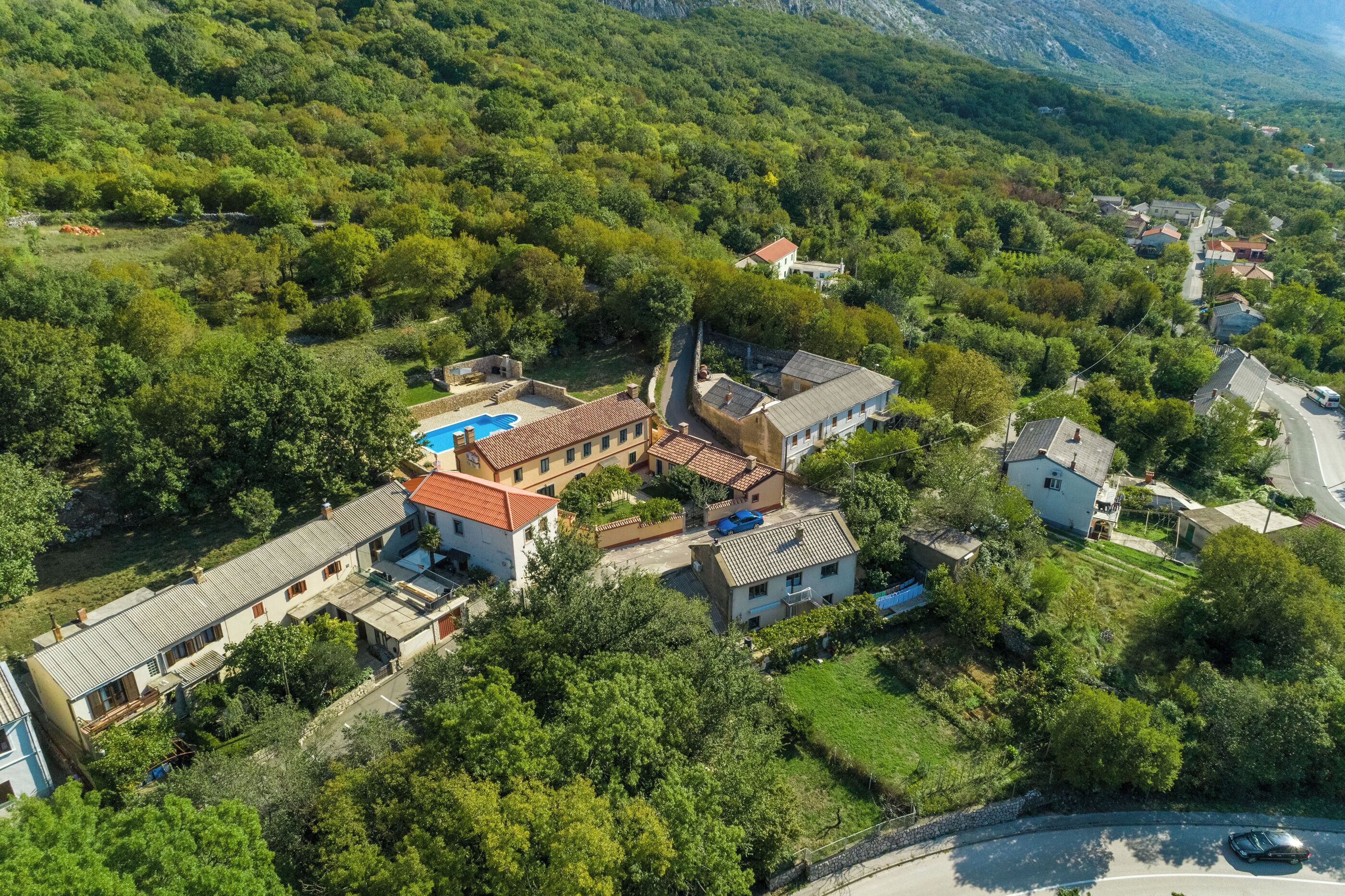 An aerial view of a residential area with houses, a swimming pool, and a church.