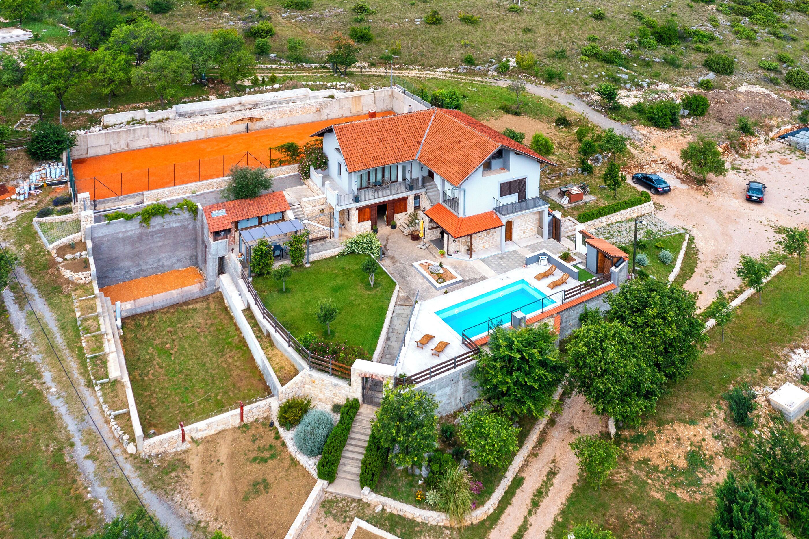 Una casa grande con piscina, jardín y zona vallada.