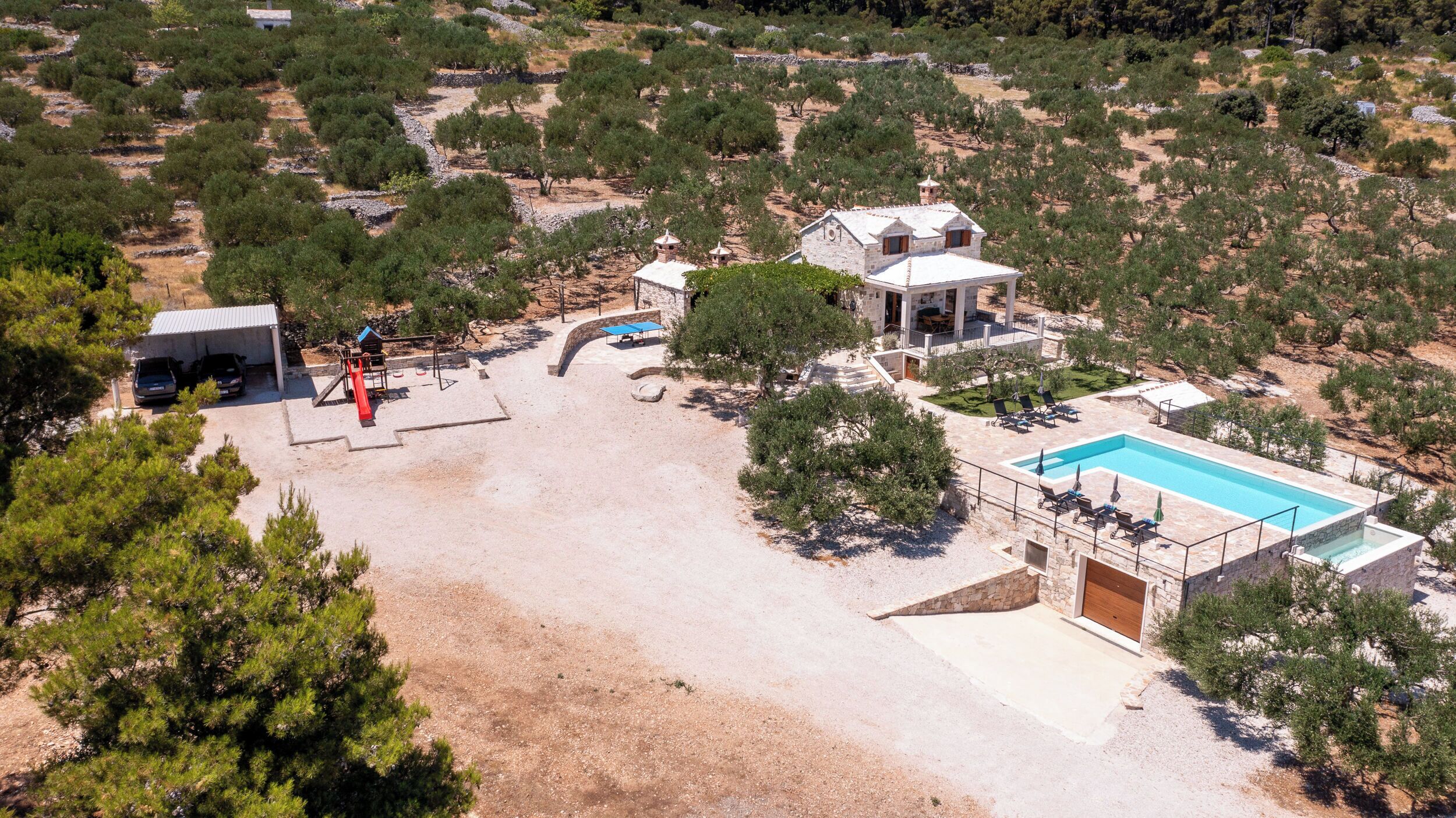 Une villa dotée d’une piscine, d’un espace extérieur aménagé et d’un chemin en pierre.