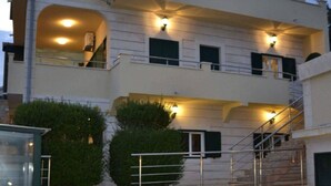 A multi-story building with balconies, a staircase, and a stone-paved entrance. - Villa Casa With Indoor Pool (Dugi Rat)
