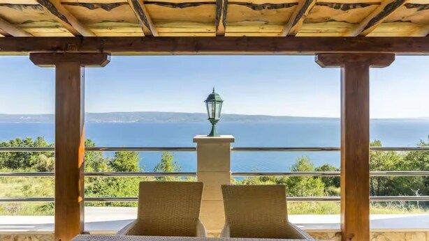 A covered outdoor seating area with a view of the sea and mountains. - Villa Casa With Indoor Pool (Dugi Rat)