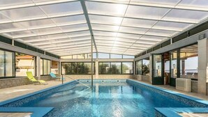 An indoor swimming pool with a glass ceiling, clear blue water, and lounge chairs. - Villa Casa With Indoor Pool (Dugi Rat)