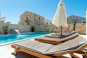Un espace aménagé au bord de la piscine, avec des chaises longues et un élément décoratif aquatique.