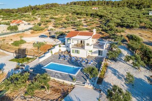 Une villa moderne dotée d’une piscine, d’un espace extérieur aménagé et offrant une vue sur le paysage environnant.