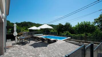Outdoor pool, a heated pool, open open 24 hours, pool umbrellas