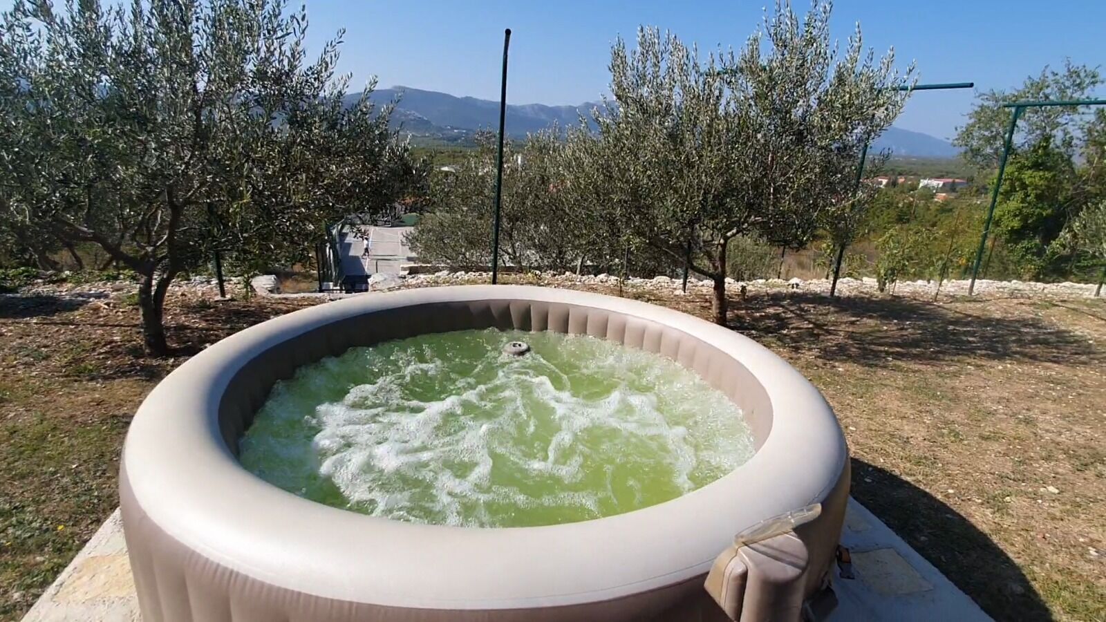 Un jacuzzi al aire libre con vistas a montañas y árboles en el fondo.