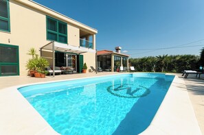 A modern house with a swimming pool, outdoor furniture, and a covered patio area. - Villa Jolanda (Trogir)