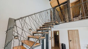 A modern staircase with a metal framework and wooden steps, leading to a loft area with a wooden ceiling. - Villa The Rock (Vodice)
