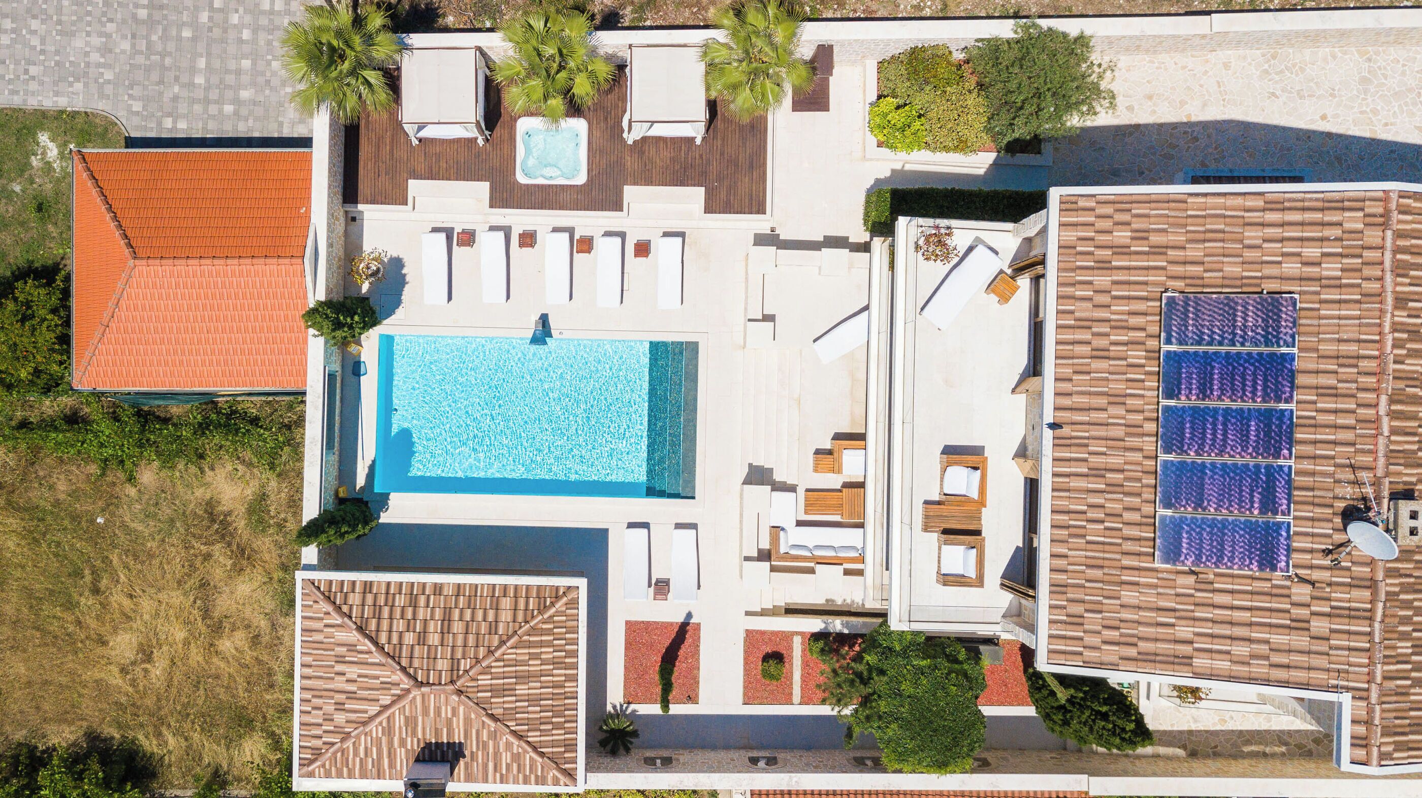 Zona d'una piscina al terrat, amb piscina, gandules i una zona de seients coberta.
