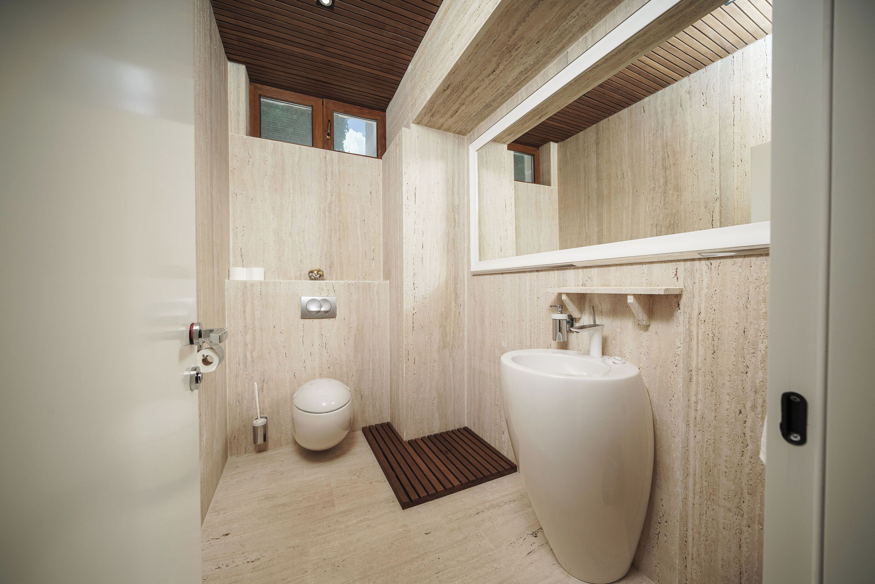 A modern bathroom with a large sink, toilet, and shower area.