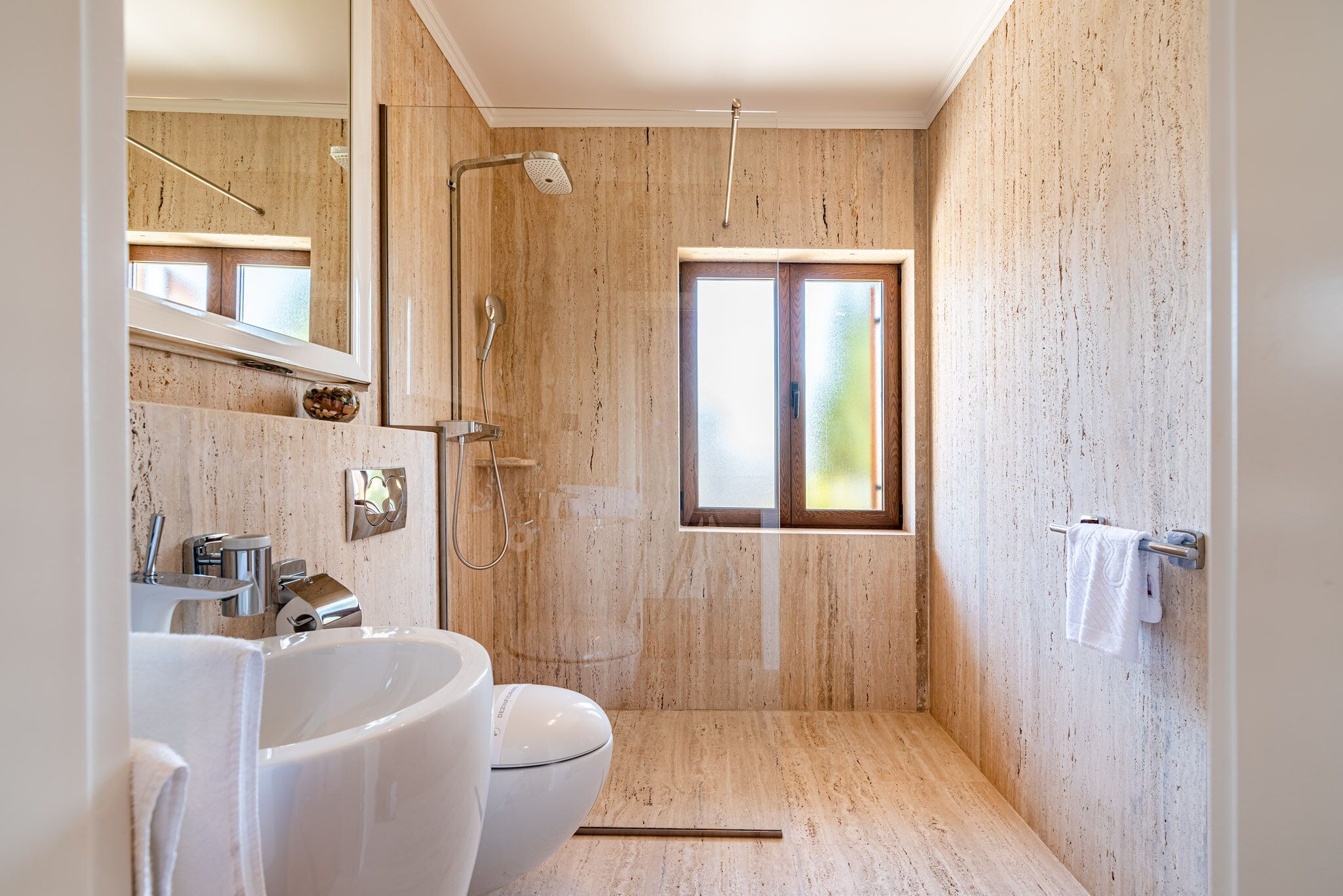 Un baño moderno con lavamanos amplio, inodoro y ducha.