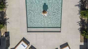 Utendørsbasseng,et oppvarmet basseng, bassengparasoller og solsenger