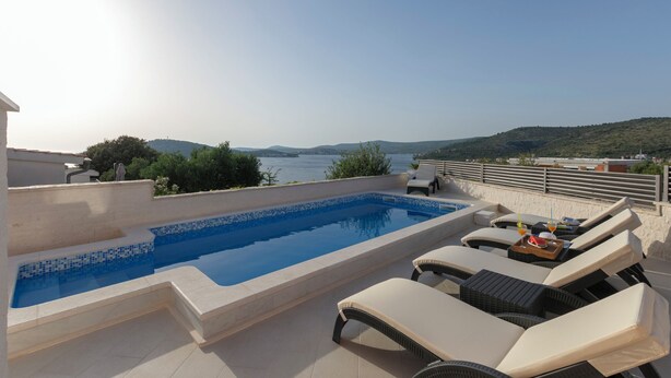 A rooftop pool with lounge chairs and a view of the sea. - Villa Patria (Rogoznica)