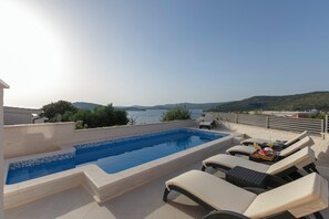 A rooftop pool with lounge chairs and a view of the sea. - Villa Patria (Rogoznica)
