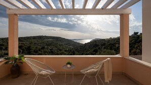 A balcony with two white wire chairs, a small round table, and a potted plant. - Villa Gospoja (Rogoznica)