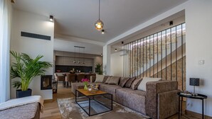 Ein modernes Wohnzimmer mit Sofa, Couchtisch und einer Treppe mit Steinlaufgeländern.