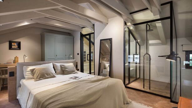 Une chambre comprenant un lit, un bureau, une armoire et un espace douche.