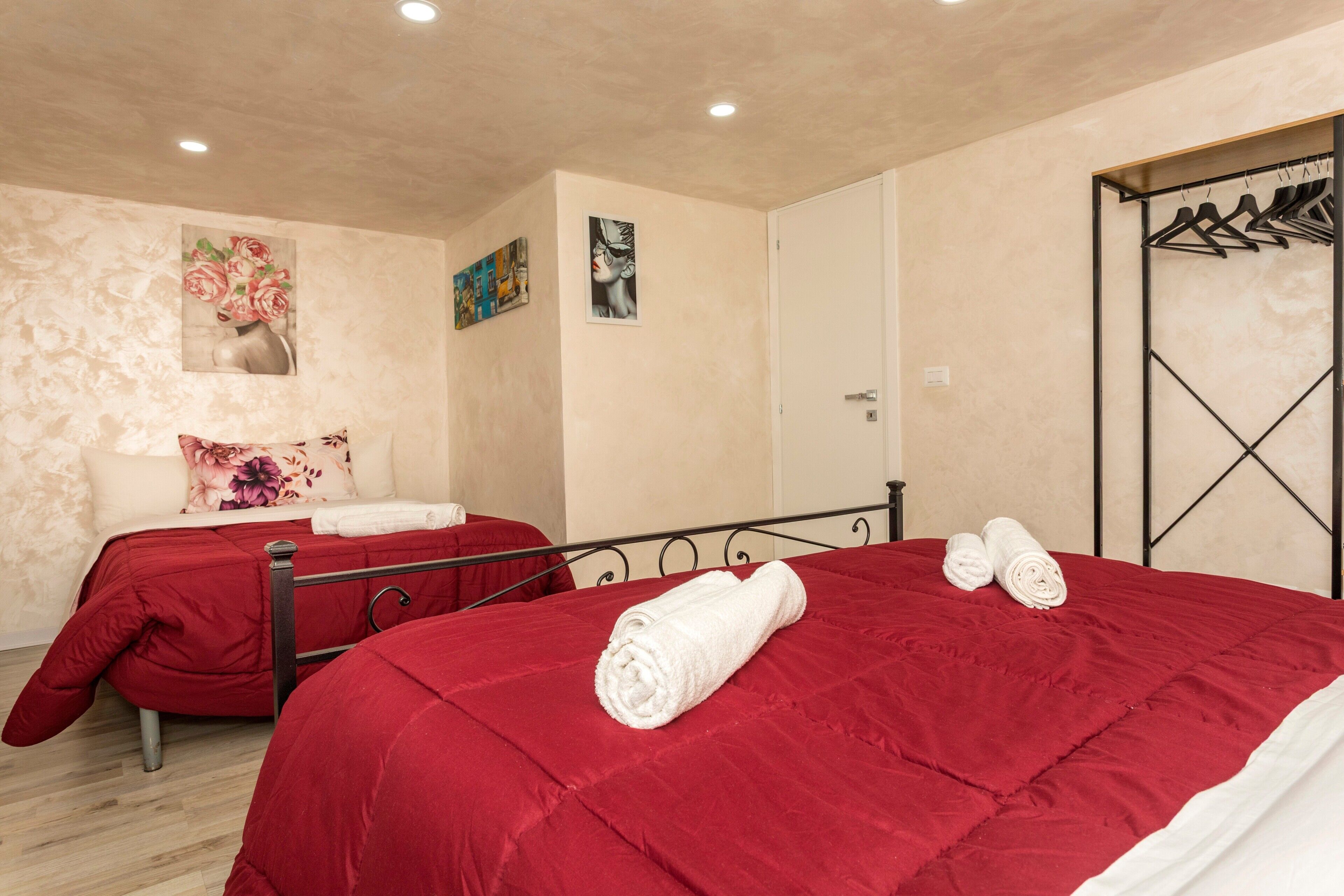 Ein Hotelzimmer mit zwei Betten, einem Kleiderschrank und Bildern an den Wänden.