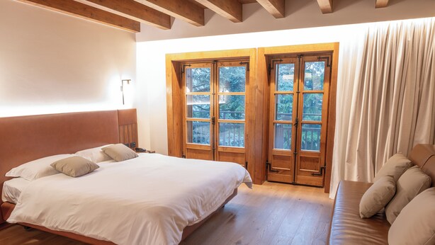 A bedroom with a large bed, wooden floor, and a window with curtains. - Rosa delle Alpi (Esino Lario)