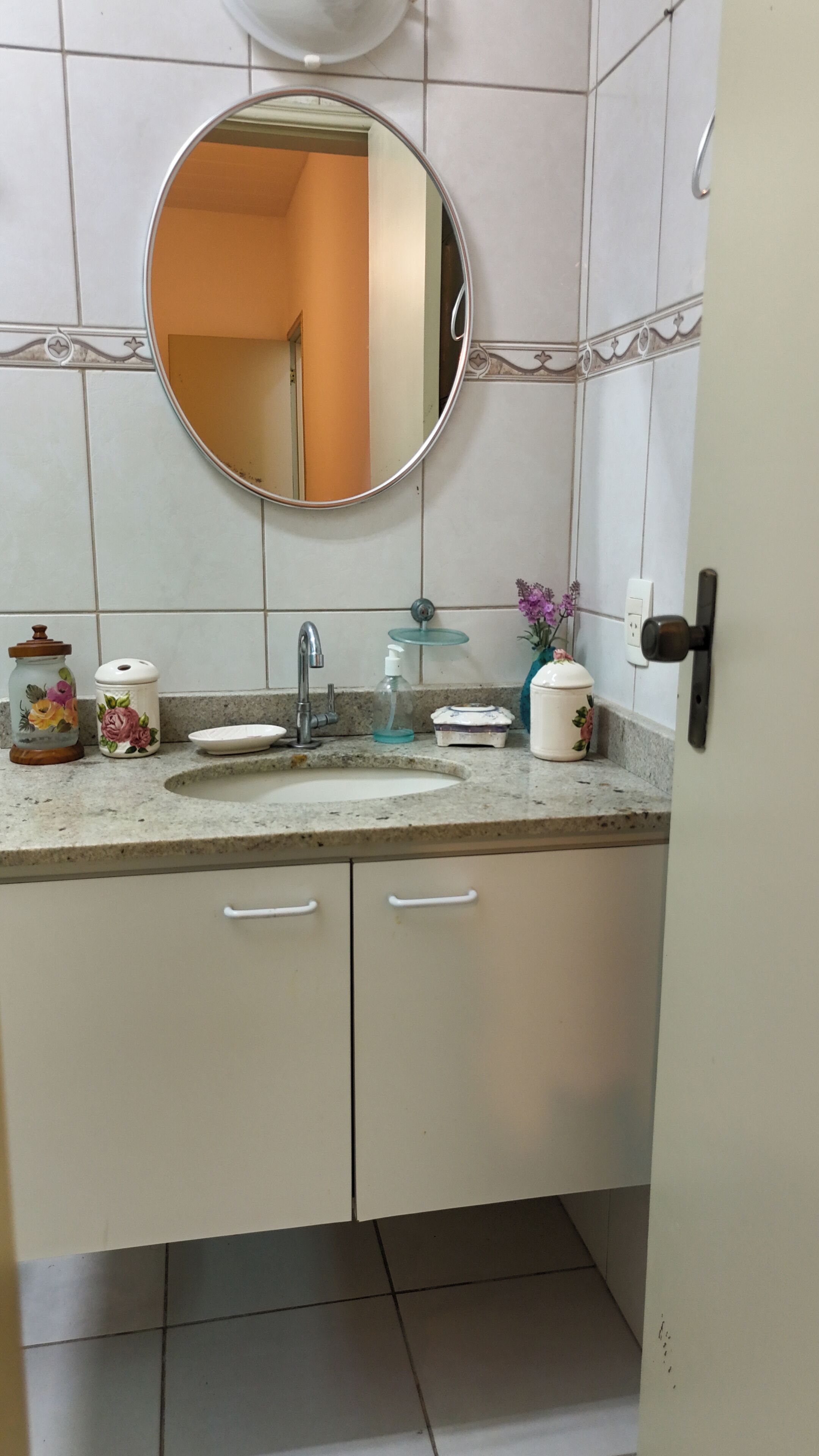 A bathroom with a sink, mirror, and cabinets.