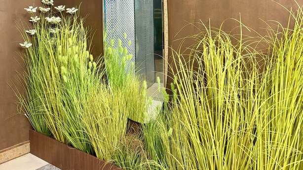 A modern interior with a concrete wall, a wooden planter with tall grasses, and a metallic elevator door. - Daegu Chilgok Money Stay 2nd Branch (Chilgok)