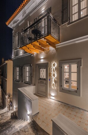 Ein zweistöckiges Gebäude mit Balkon und Treppe, mit einem Schild, auf dem 'ONORA' steht.