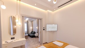 Una moderna camera d'albergo con un letto grande, un comò con uno specchio e una televisione appesa al muro.