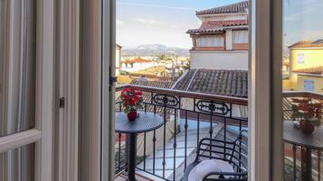Un balcón con vistas a edificios y montañas.