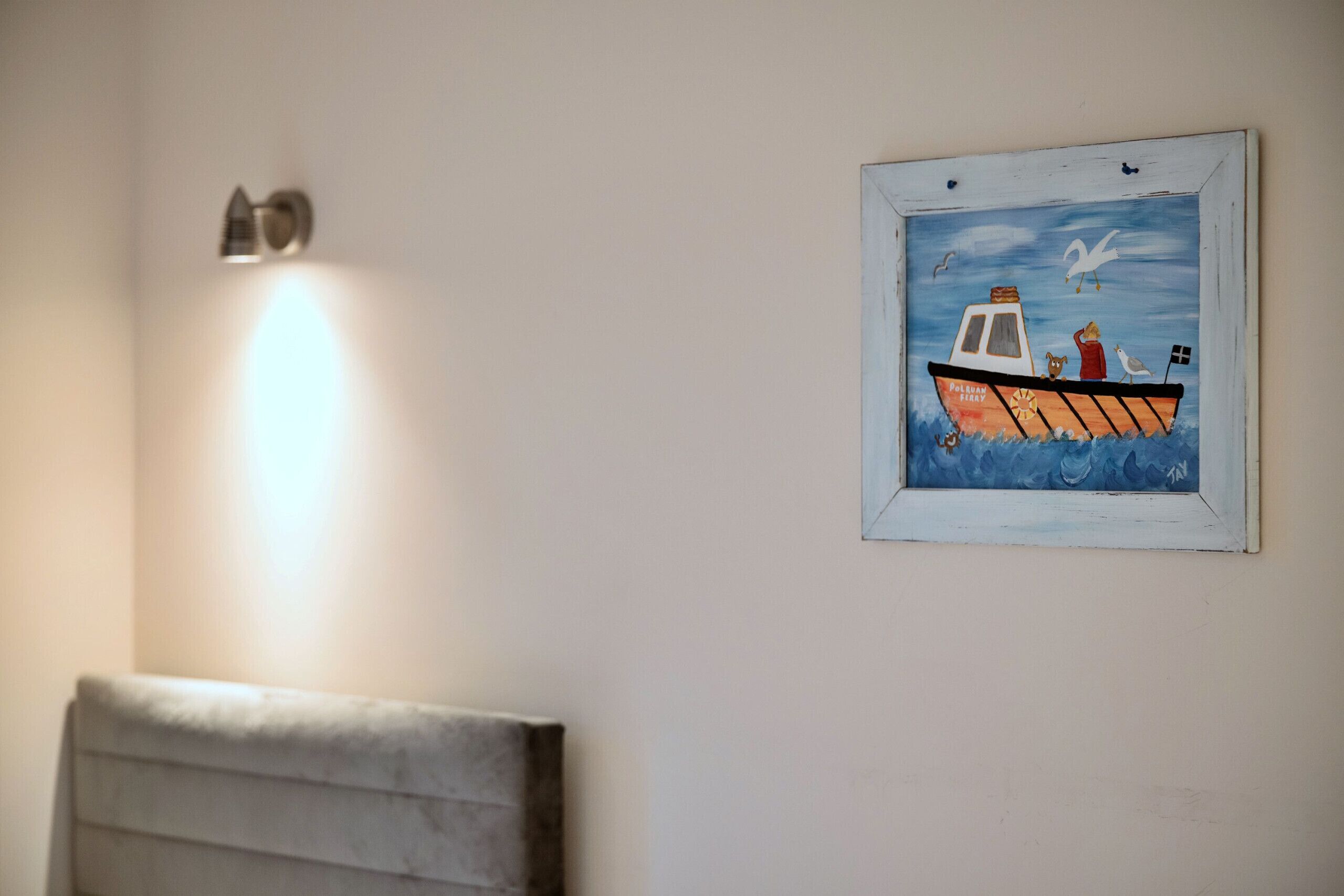 A framed painting of a boat with a seagull and a dog on the wall.