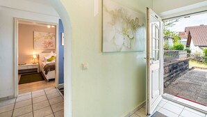 A hotel room with a bed, a bedside table, a lamp, and a painting on the wall. - Baden-Chalet – Charming Apartment with Views over the Rhine Valley (Bühl)