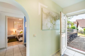 A hotel room with a bed, a bedside table, a lamp, and a painting on the wall. - Baden-Chalet – Charming Apartment with Views over the Rhine Valley (Bühl)